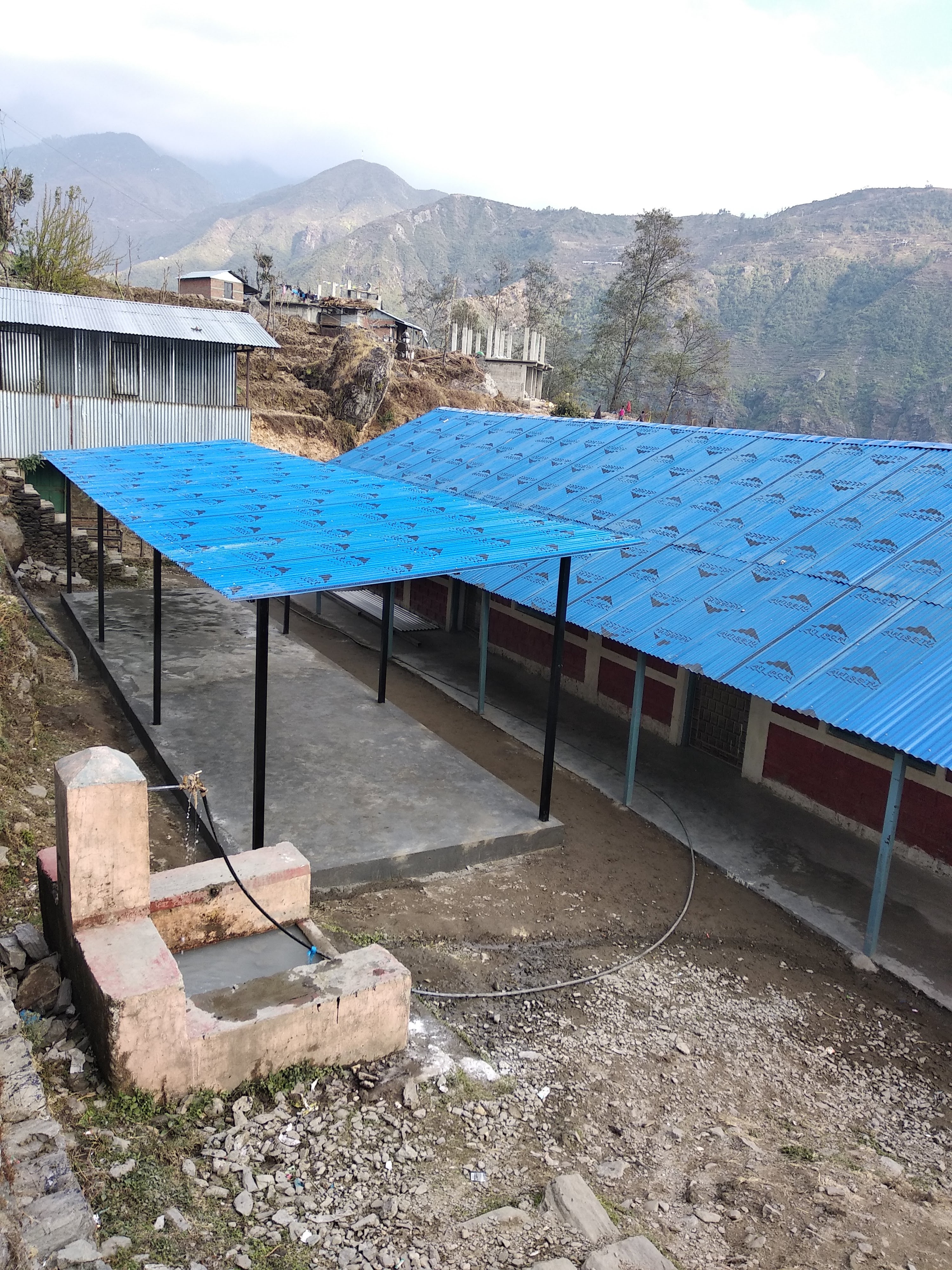 Completed covered outdoor learning area beside a school in Rasuwa